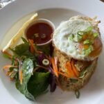 Sri Lankan style chicken fried rice, fried eggs, Asian spicy salad, and Homemade hot sauce